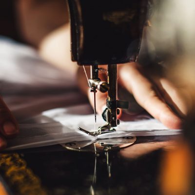 Vintage sewing machine and woman's hands, sewing process
